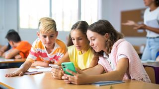 Kids with cellphones in classroom