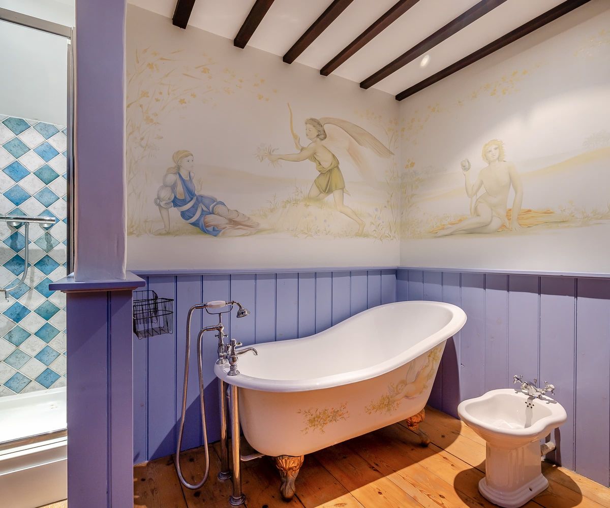 A bathroom with purple walls and separate shower