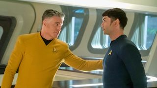 (L to R) Anson Mount as Pike, extends and arm to Ethan Peck as Spock in Star Trek: Strange New Worlds