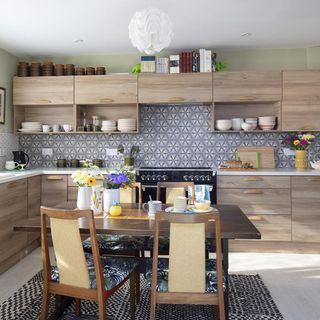 kitchen with patterned tiles and dining table with chairs and shelf