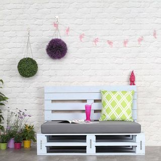 white wall with blue pallet and flower plants