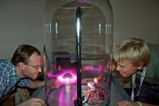 NASA researcher Guillaume Gronoff (left) examines Planeterrella with intern Sam Walker. The device recreates the northern lights from Earth and other planets.