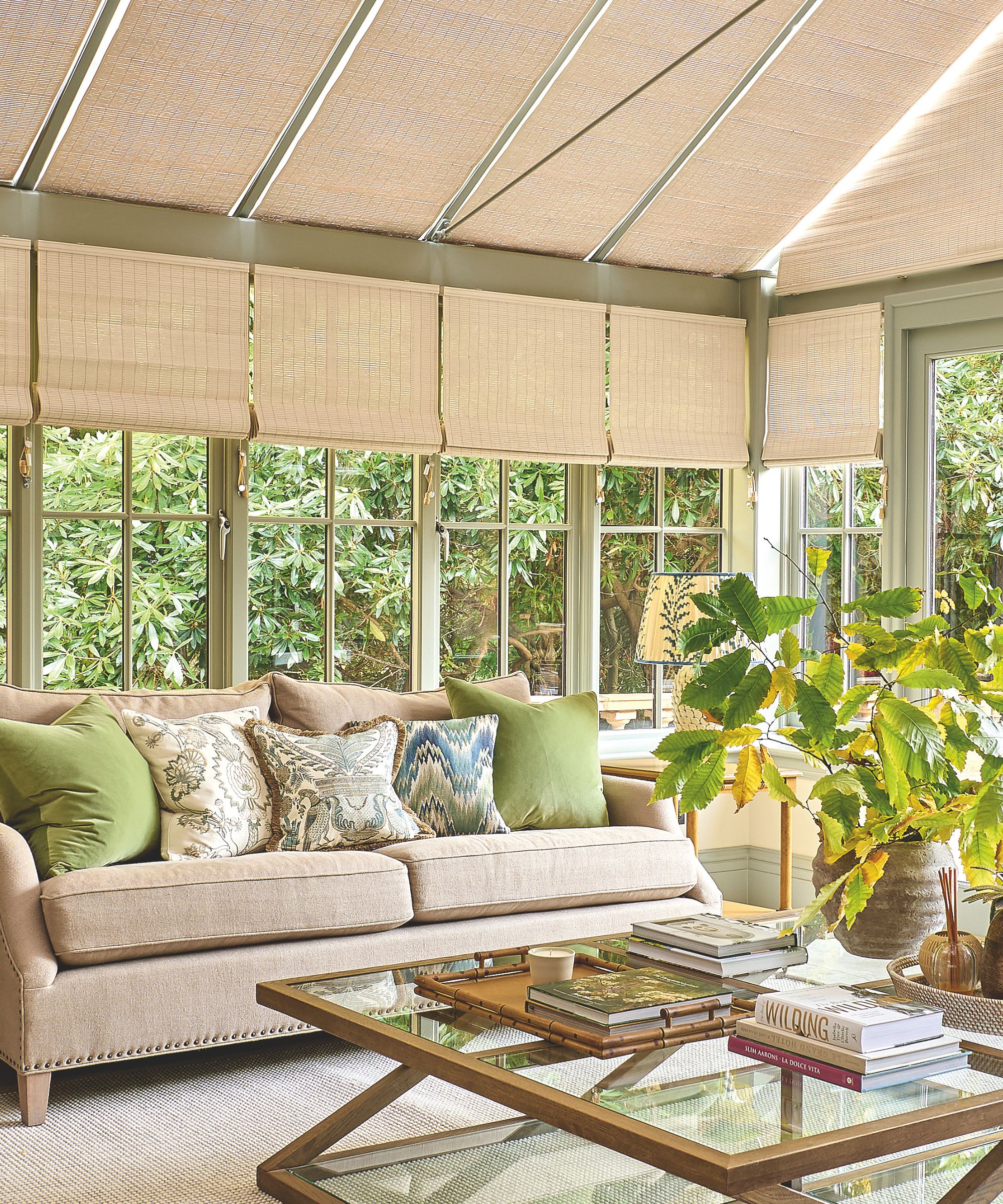 Pale green sunroom with rattan shades and pale beige sofa