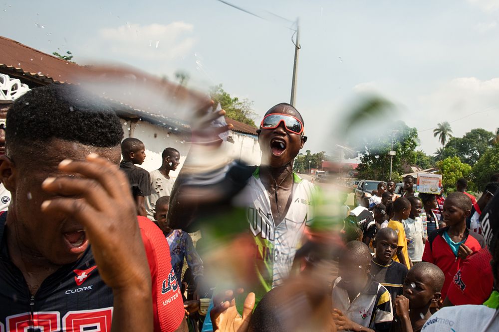 White jersey winner Ibrahim Jalloh throwing water over Moses L Kamara, who was third on GC
