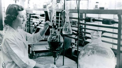 View of an unidentified chemist as she works with various flaks in a laboratory, May 23, 1958.