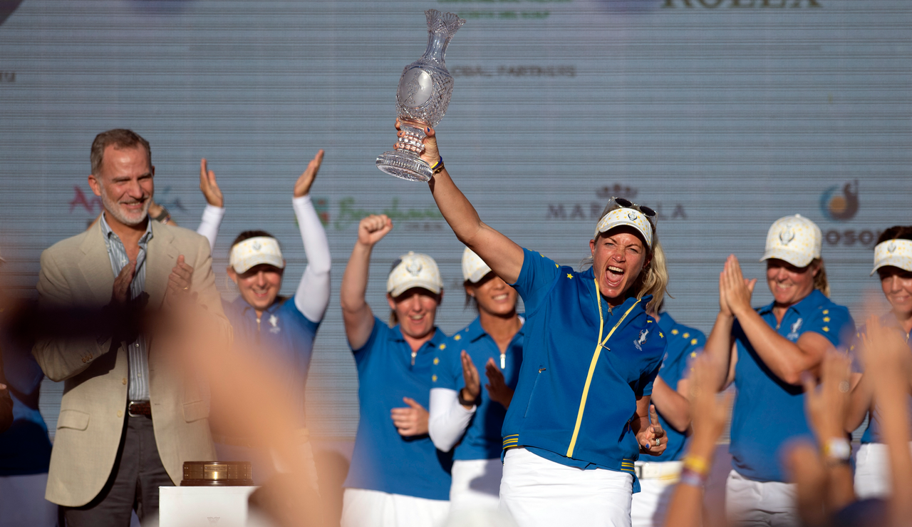 Suzann Petersen holds the Solheim Cup trophy aloft