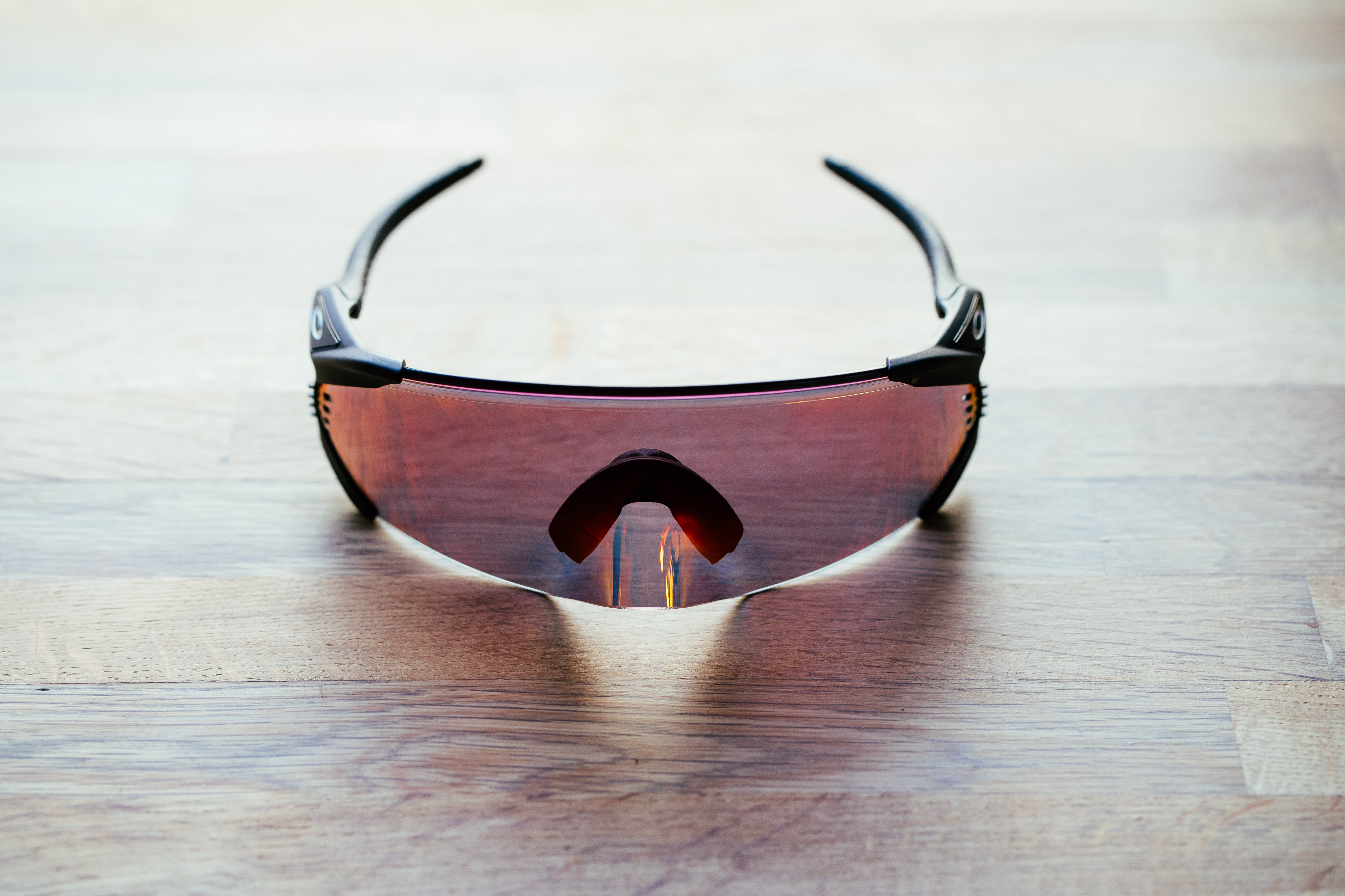 A set of large wraparound sports glasses on a wooden surface