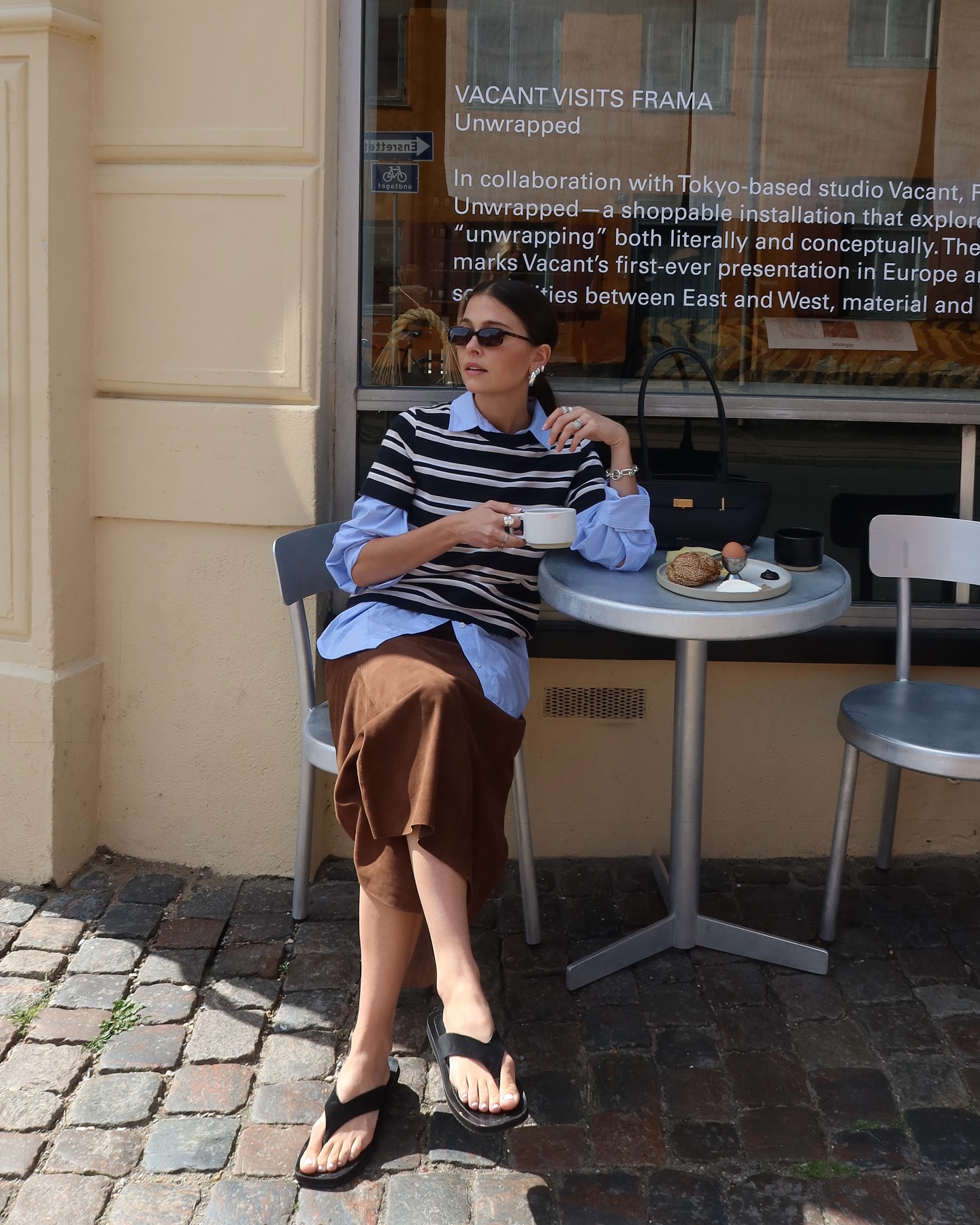 Alice wears an a blue shirt, stripe tee and a suede skirt with flip flops.