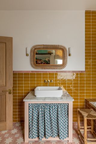 Bathroom with yellow subway tiles and vanity with blue sink skirt Barlow & Barlow