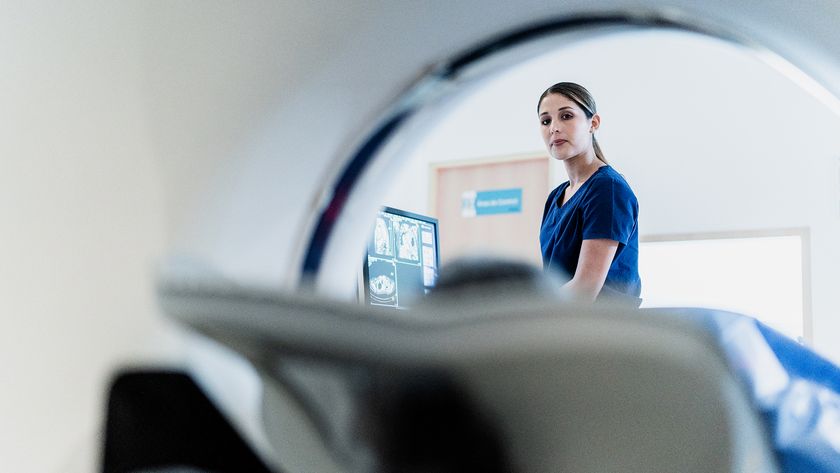 Portrait of a female nurse preparing patient for a tomography exam at hospital at hospital.