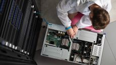 A technician servicing a rack-mounted node within a supercomputer.