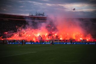 Red Star Belgrade fans light flares in a derby against Partizan in February 2022.