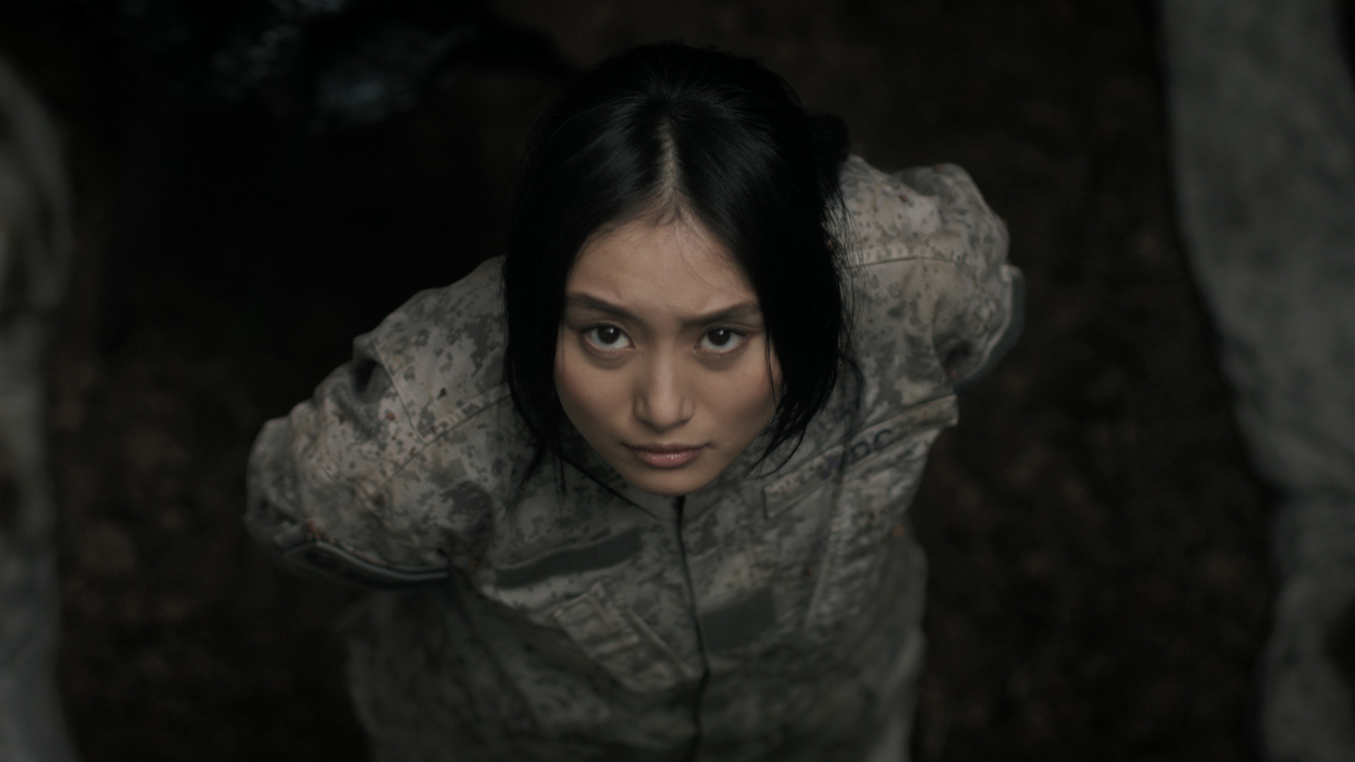 一個穿著士兵制服的女人從一個洞裡往外看