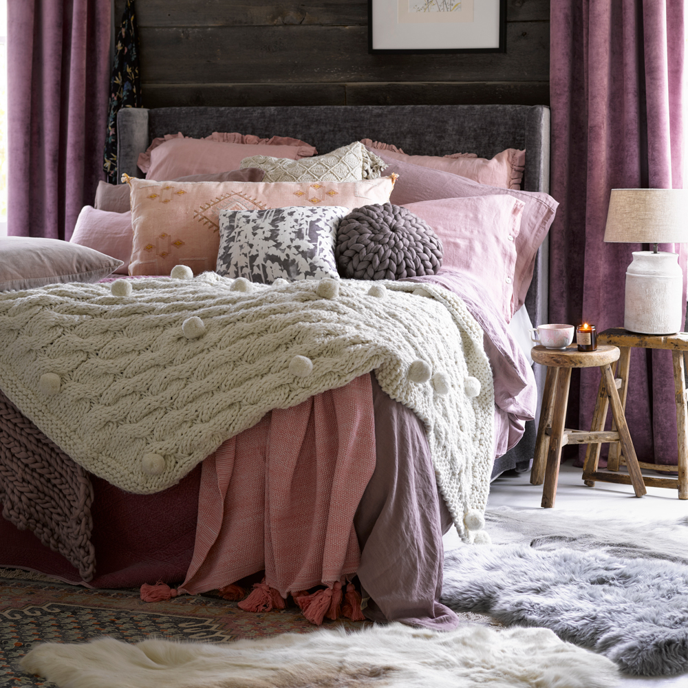 bedroom with brown wooden wall bed with designed cushions and wooden table