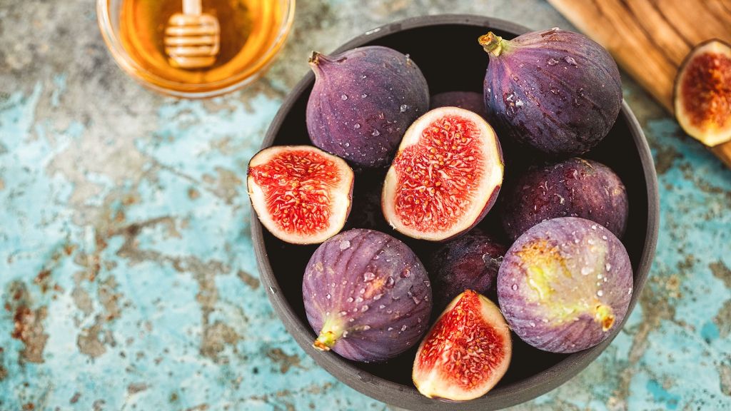 fresh figs in bowl, honey in background 