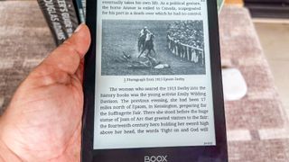 A hand holding the Onyx Boox Go 6 showing a page with image displayed