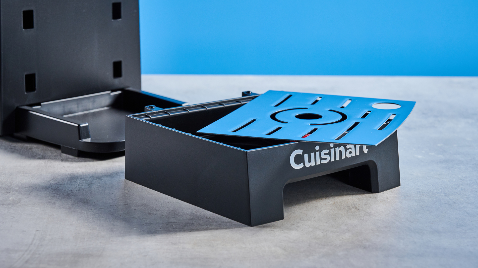 The Cuisinart Espresso Bar Slim espresso machine on a stone surface with a blue background