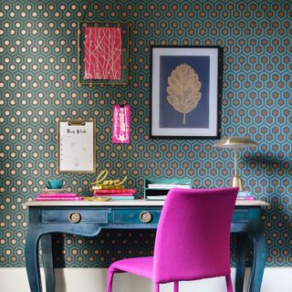 room with wallpaper wall and desk with pink chair