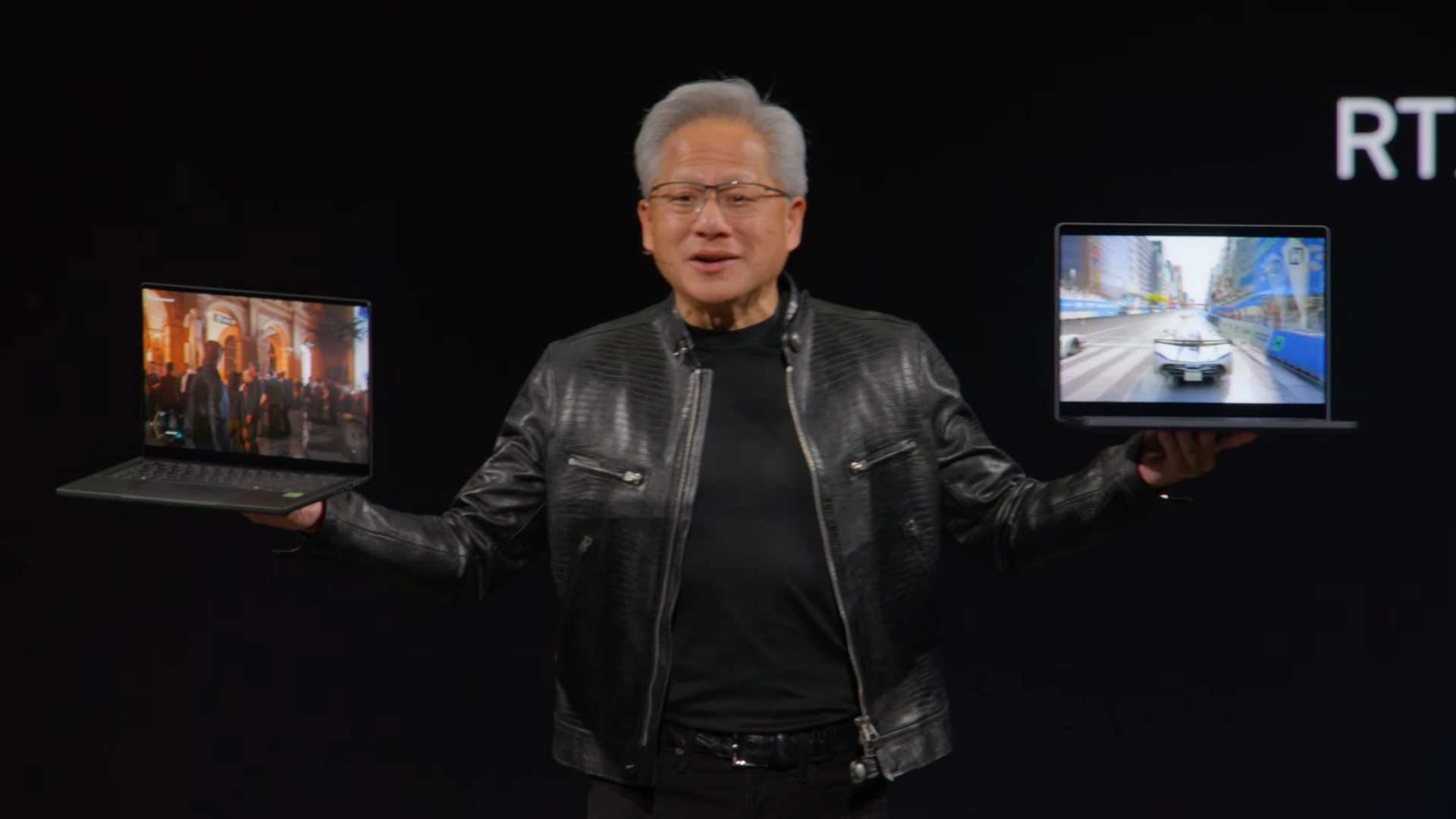 Nvidia CEO Jensen Huang holding two gaming laptops at the Spark superchip reveal at Computex 2026