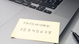 A sticky note on a laptop reading "password 12345678"