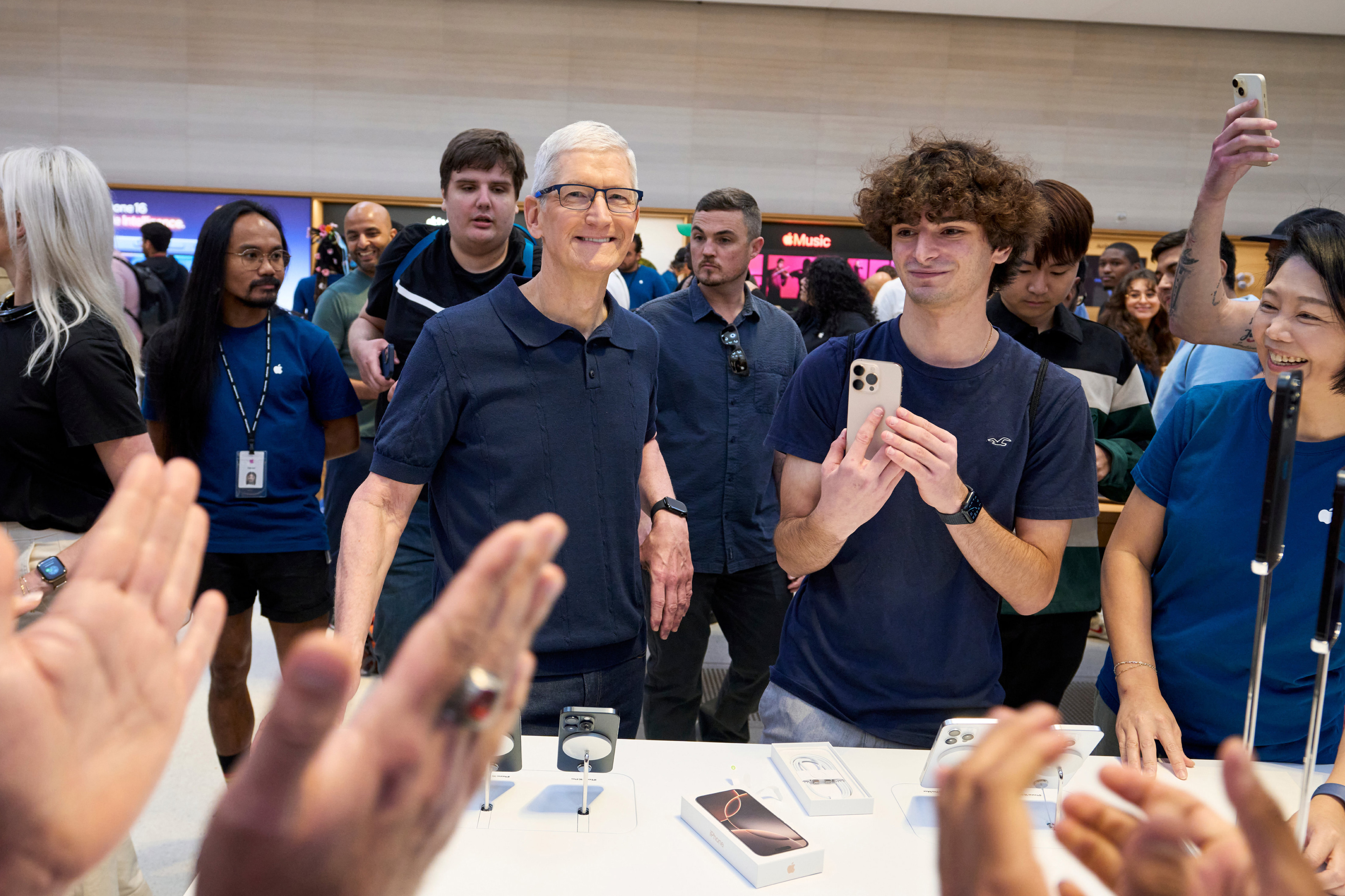 Apple CEO Tim Cook surrounded by people at an Apple event