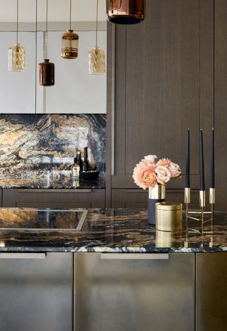 patterned stone countertop on kitchen island with pendant lights and flowers