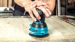 Generic orbital sander being used by two hands