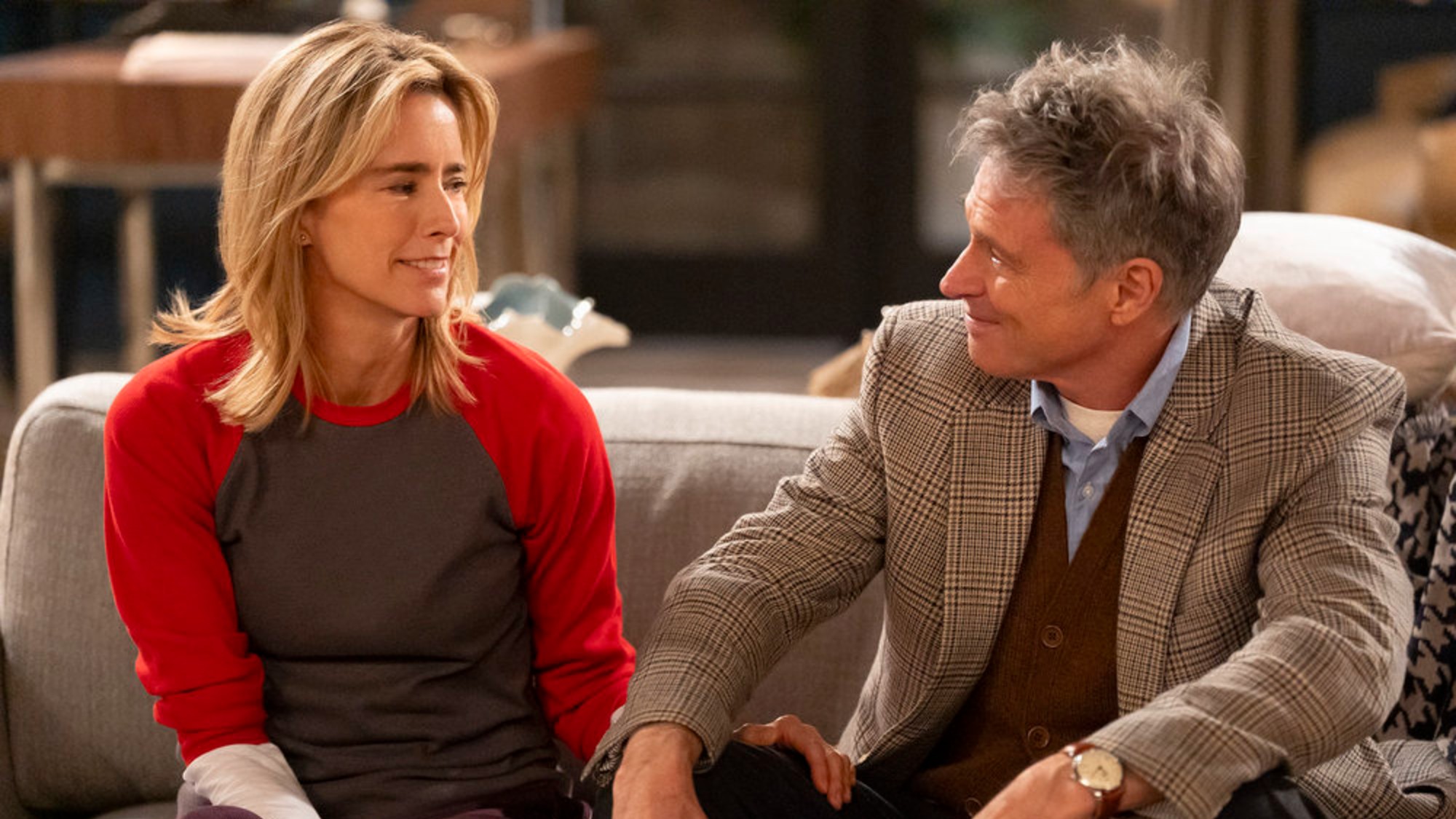 T&eacute;a Leoni as Jeanie and Tim Daly as James sitting on a couch together on NBC's Newlyweds.