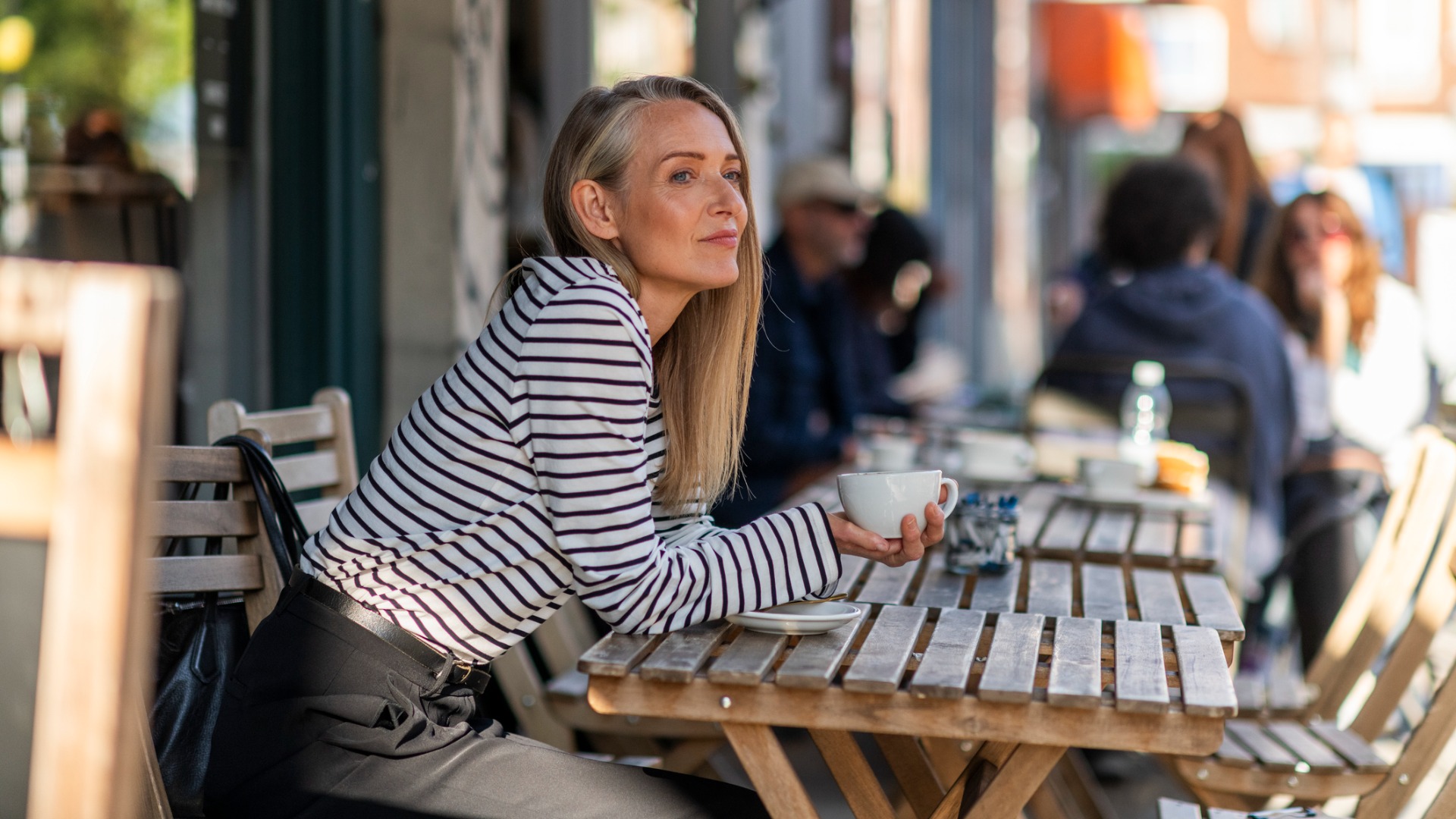 Middle aged woman drinking coffee alone
