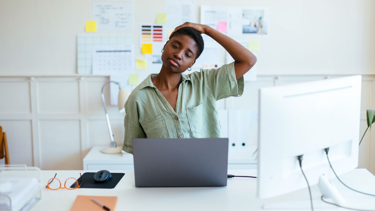 Woman doing neck stretch at desk