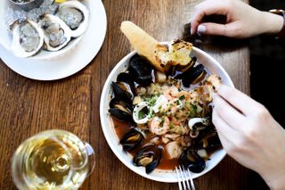 A bowl filled with fresh seafood and a plate of raw seafood at The Mooring Seafood Kitchen & Bar in Newport, Rhode Island