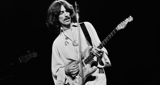 George Harrison plays his Rocky Fender Stratocaster live onstage during the 1974 tour for Dark Horse.