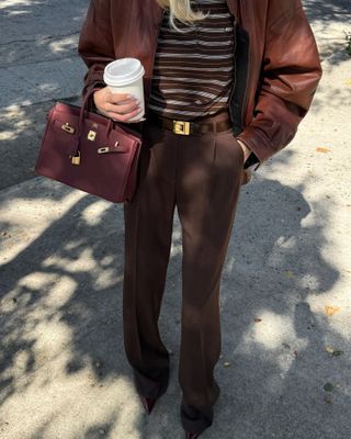 Woman wearing burgundy bag.