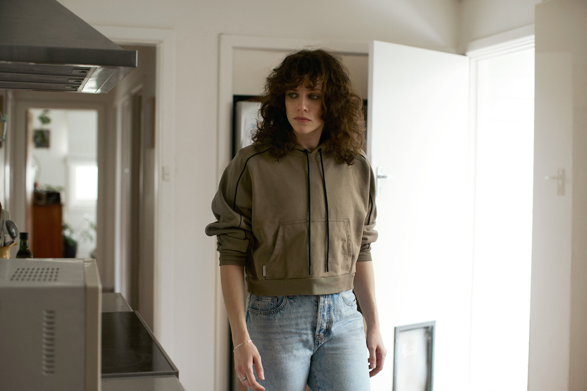jessica de gouw as olivia walking around a room in a still from the survivors