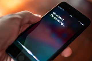 An iPhone user activating Siri