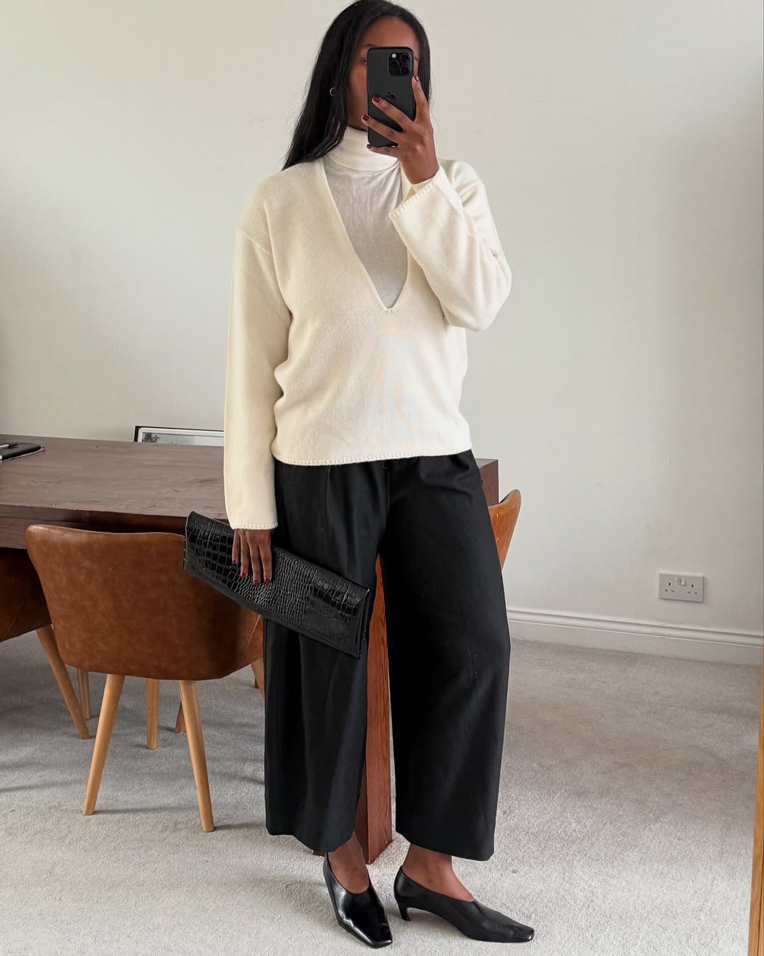@nlmarilyn wearing a v-neck over a turtleneck with trousers