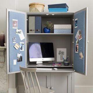 room with white walls cupboard and white wishbone chair