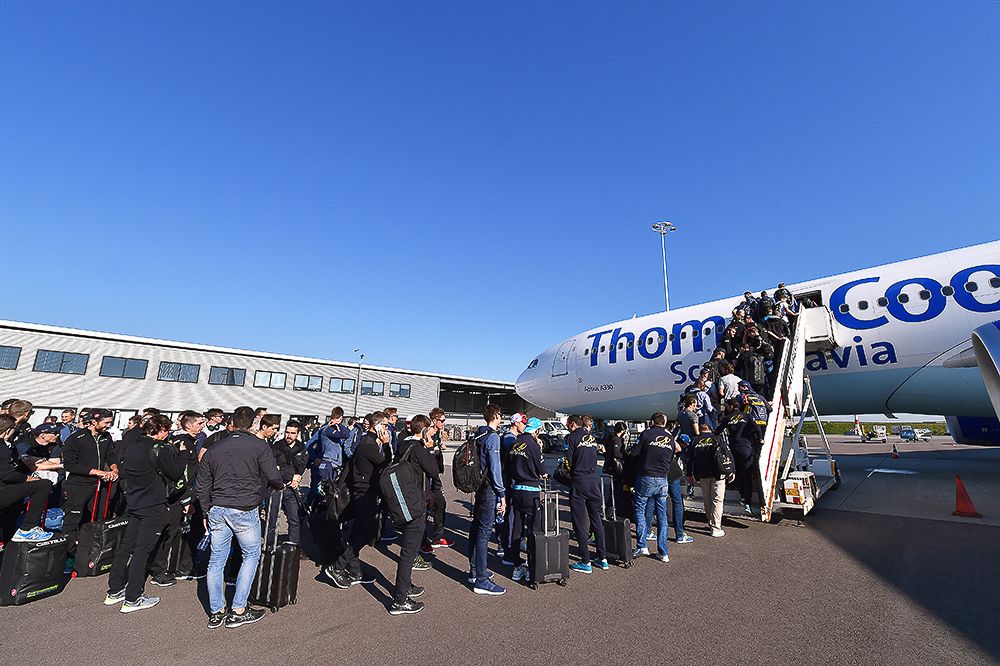 Teams line up to get on the charter plane that will take them to Italy.