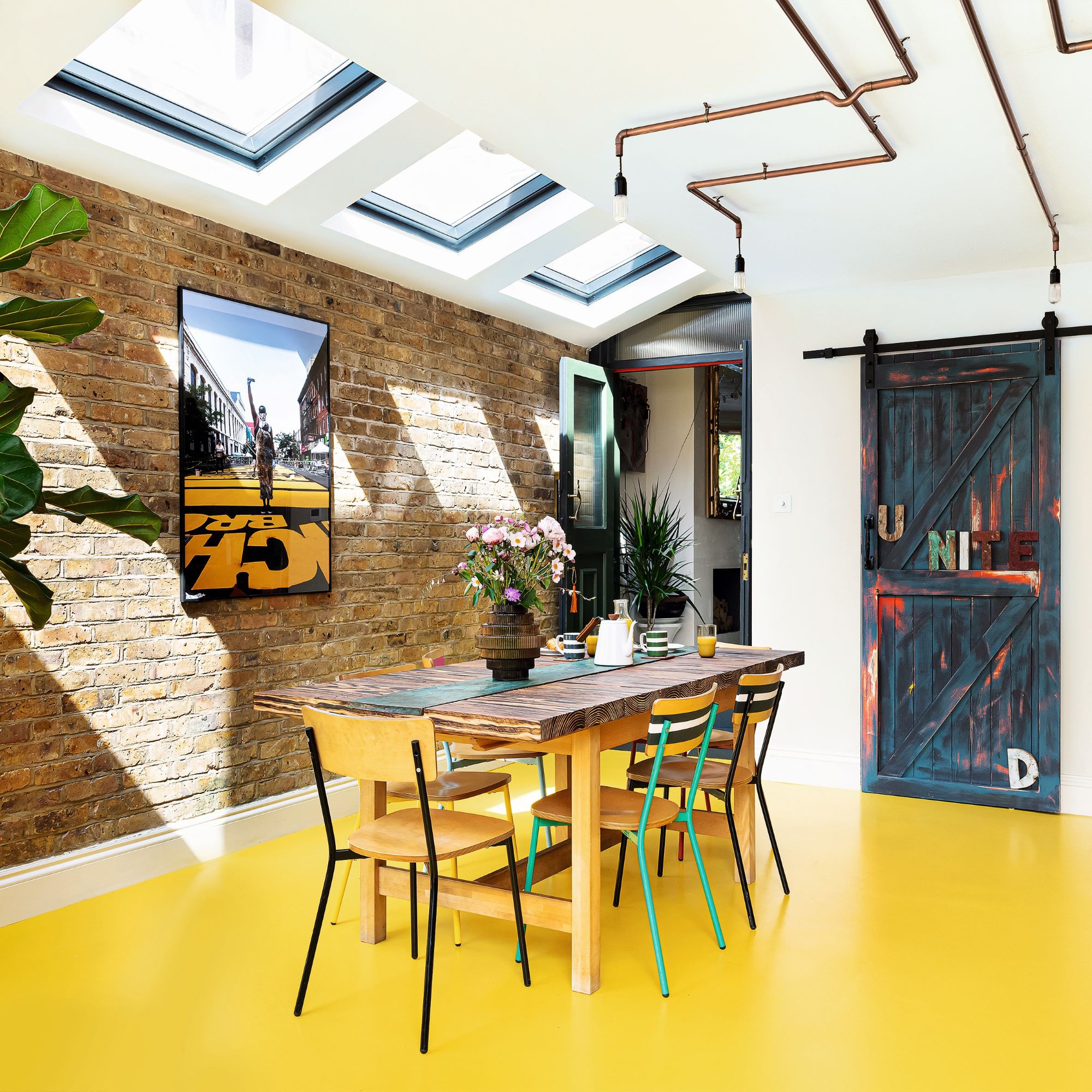 Yellow kitchen floor with brick and white wall under skylight