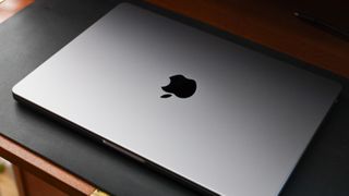 Closed lid of an Apple MacBook Pro sitting on a desk