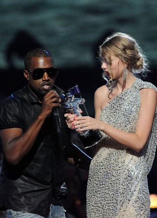 Kayne West (L) jumps onstage as Taylor Swift accepts her award for the "Best Female Video" award during the 2009 MTV Video Music Awards