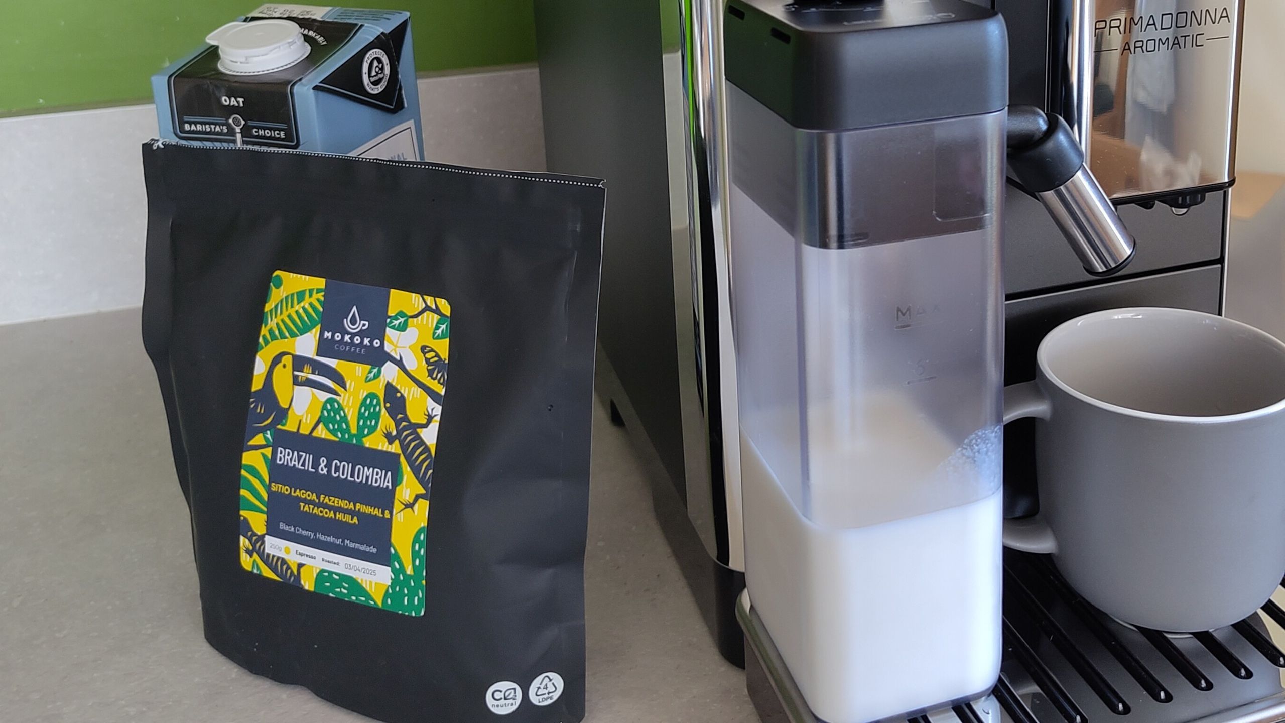 Coffee beans beside DeLonghi Primadonna Aromatic coffee maker