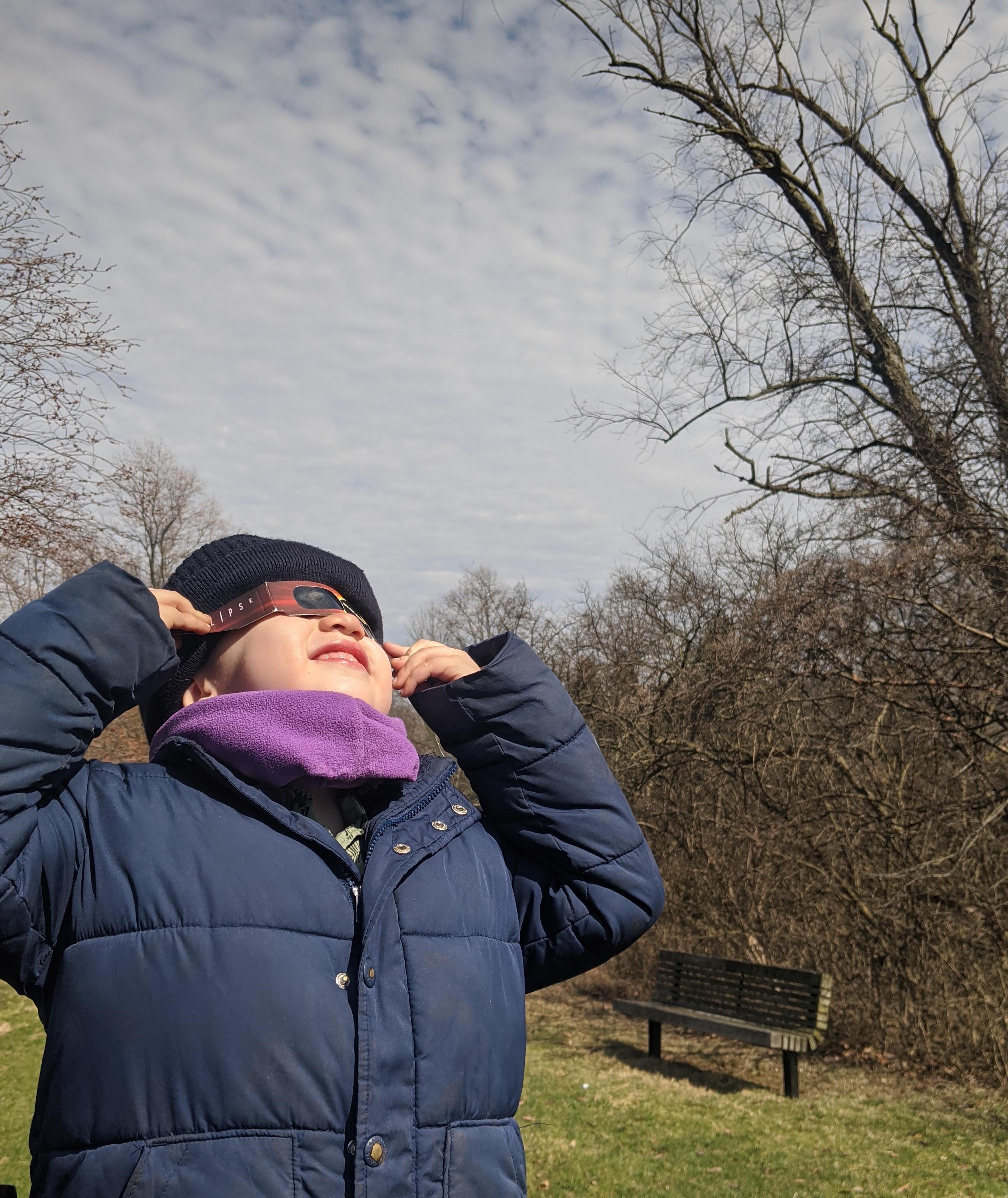Un niño mira al sol con gafas solares el 8 de abril de 2024