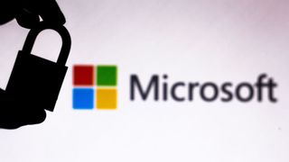 Someone holding a padlock in front of the Microsoft logo