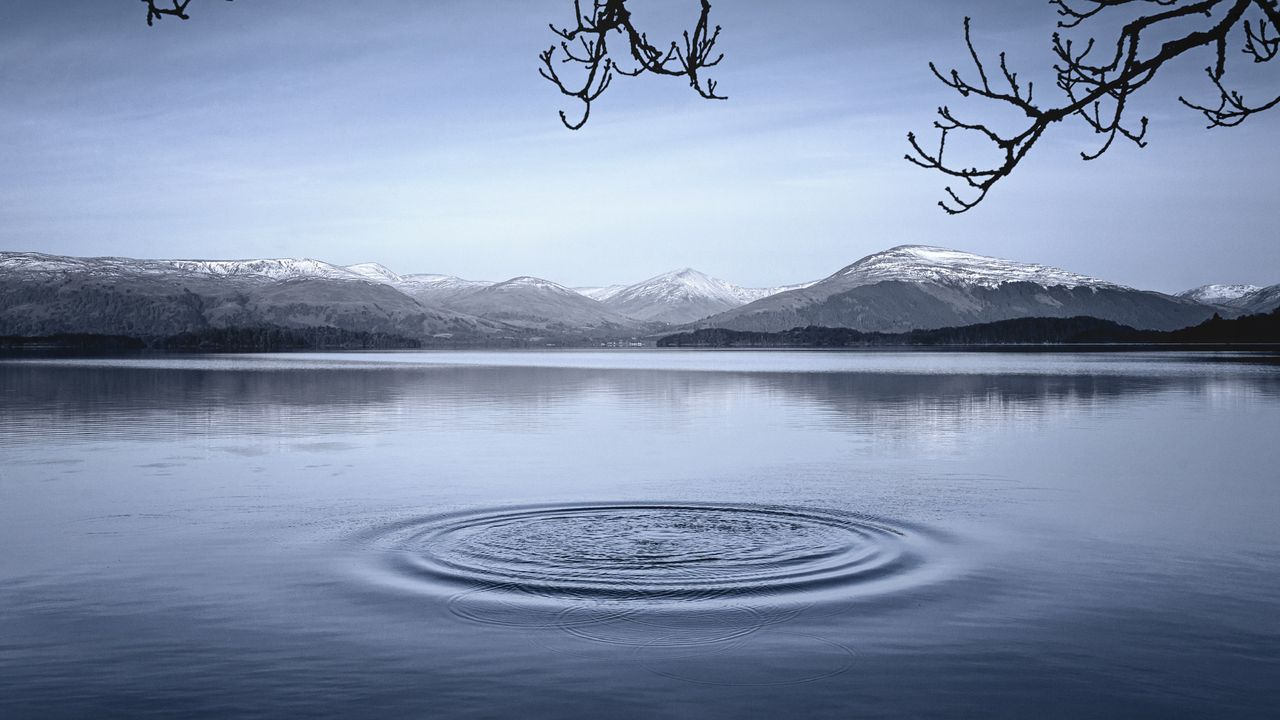 Ripples on a lake with mountains in the background.