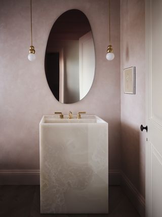 A bathroom with a pink onyx sink