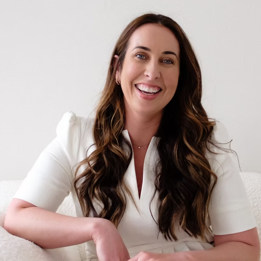Image of Dr Emma Goulding smiling with long curled brunette hair and wearing a white dres