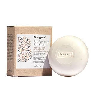 A Be Gentle, Be Kind Briogeo shampoo bar next to its container