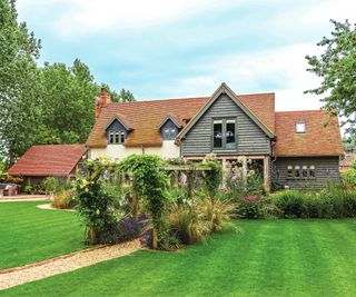 large house and surrounding gardens with green lawns and trees