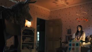 Disclosure Day's scene with the deer and the bird as seen in the Universal trailer. A young girl sits on a bed staring at them. 